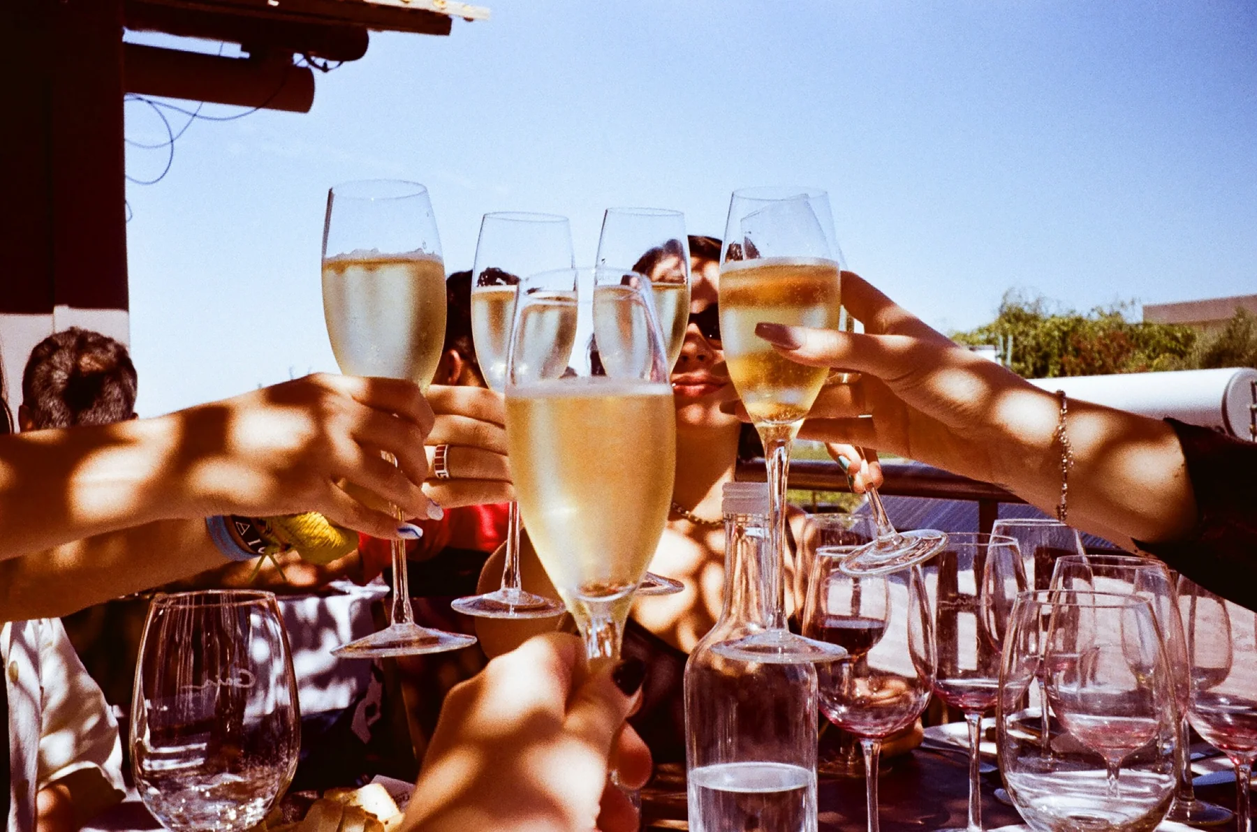 Friends raising glasses around an outdoor table