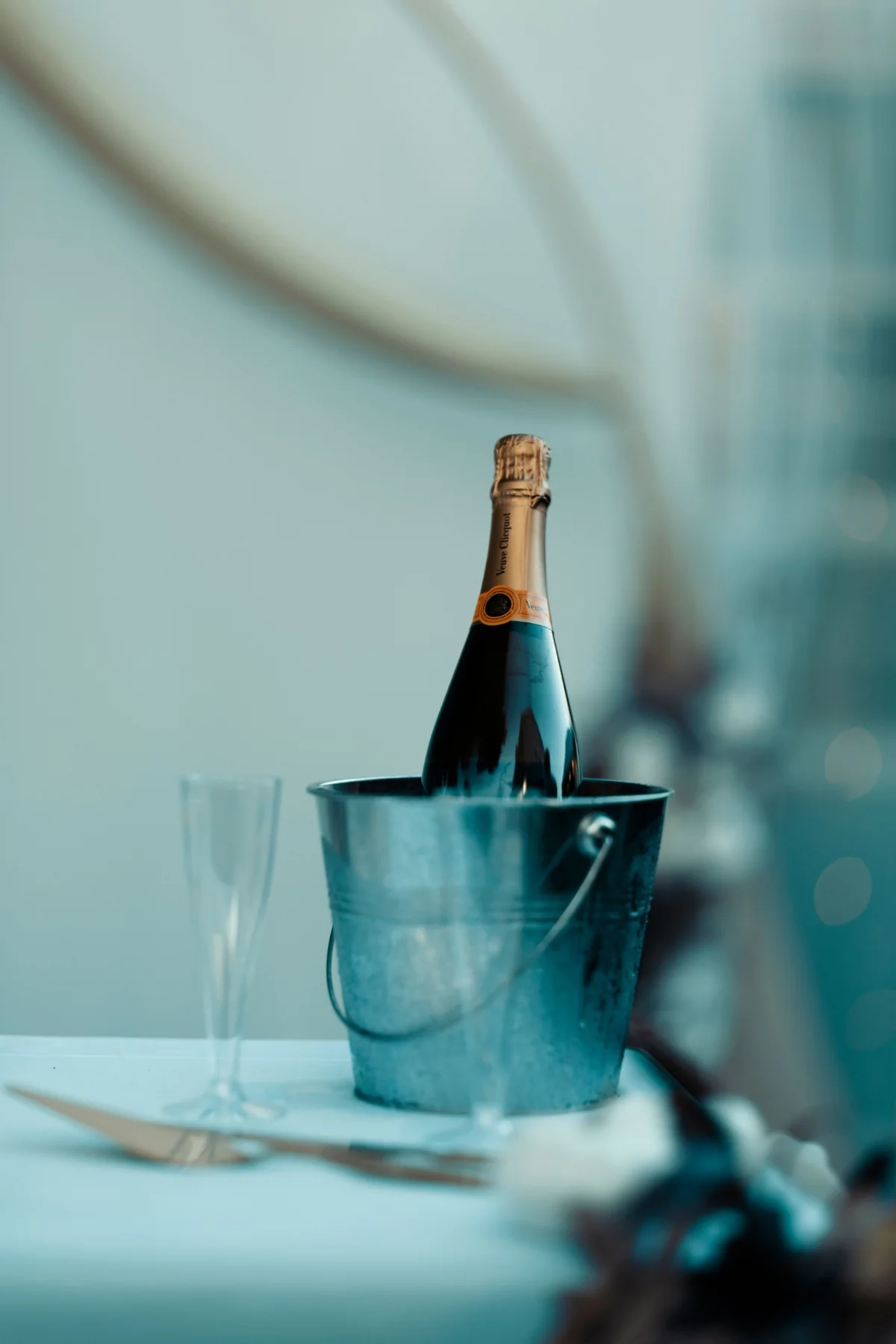 A bottle of champagne chilling beside a place setting